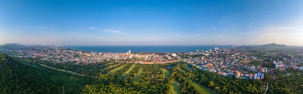 Property in Hua Hin Thailand showing a luxury villa with infinity pool overlooking the coastline at sunset